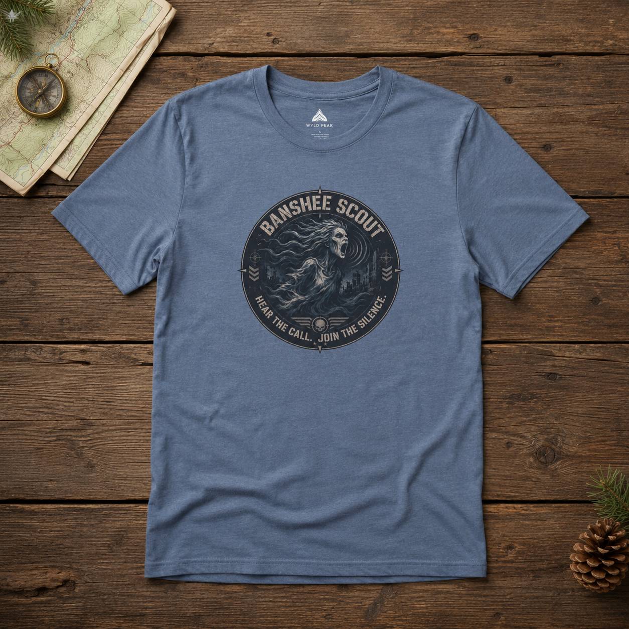 Blue t-shirt with 'Banshee Scout' graphic on a wooden surface