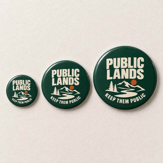 Three round pin-back buttons in dark green with a white mountain, river, and trees graphic, plus the words 'PUBLIC LANDS' and 'KEEP THEM PUBLIC' in white, displayed on a light beige background.