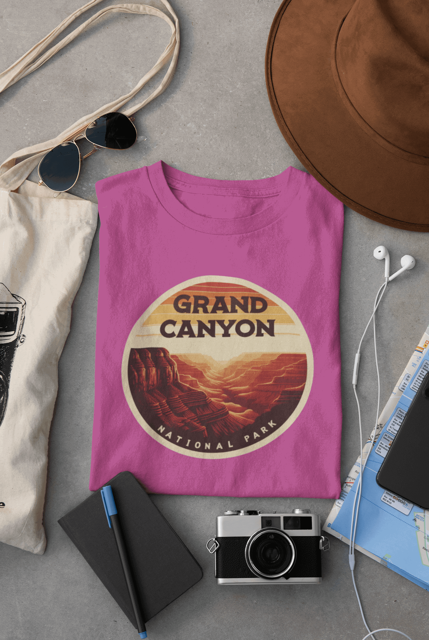 Wyld Peak Grand Canyon National Park organic cotton tee in pink laid flat on desk.