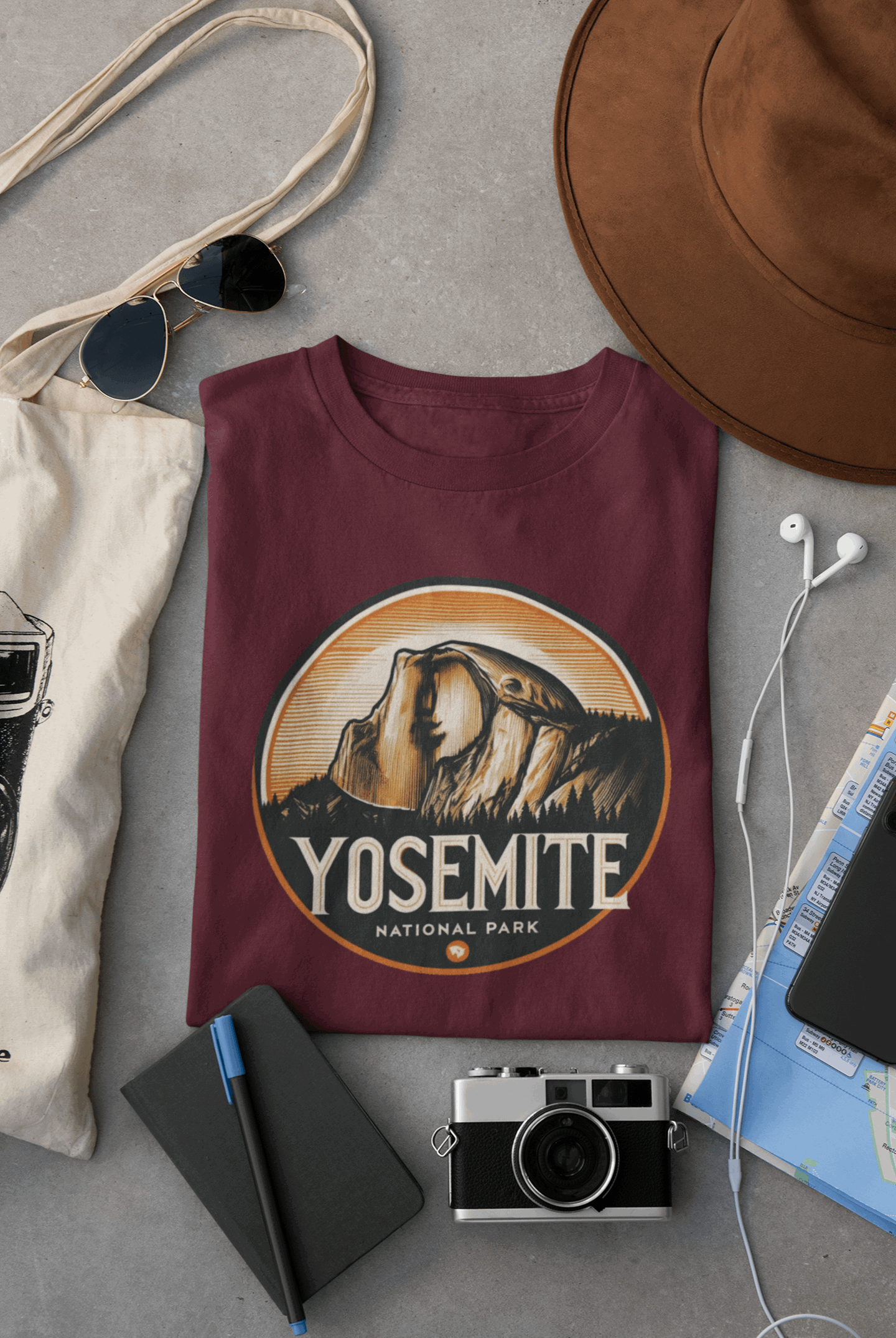 Maroon Wyld Peak Yosemite Half Dome organic cotton tee laid flat on desk.