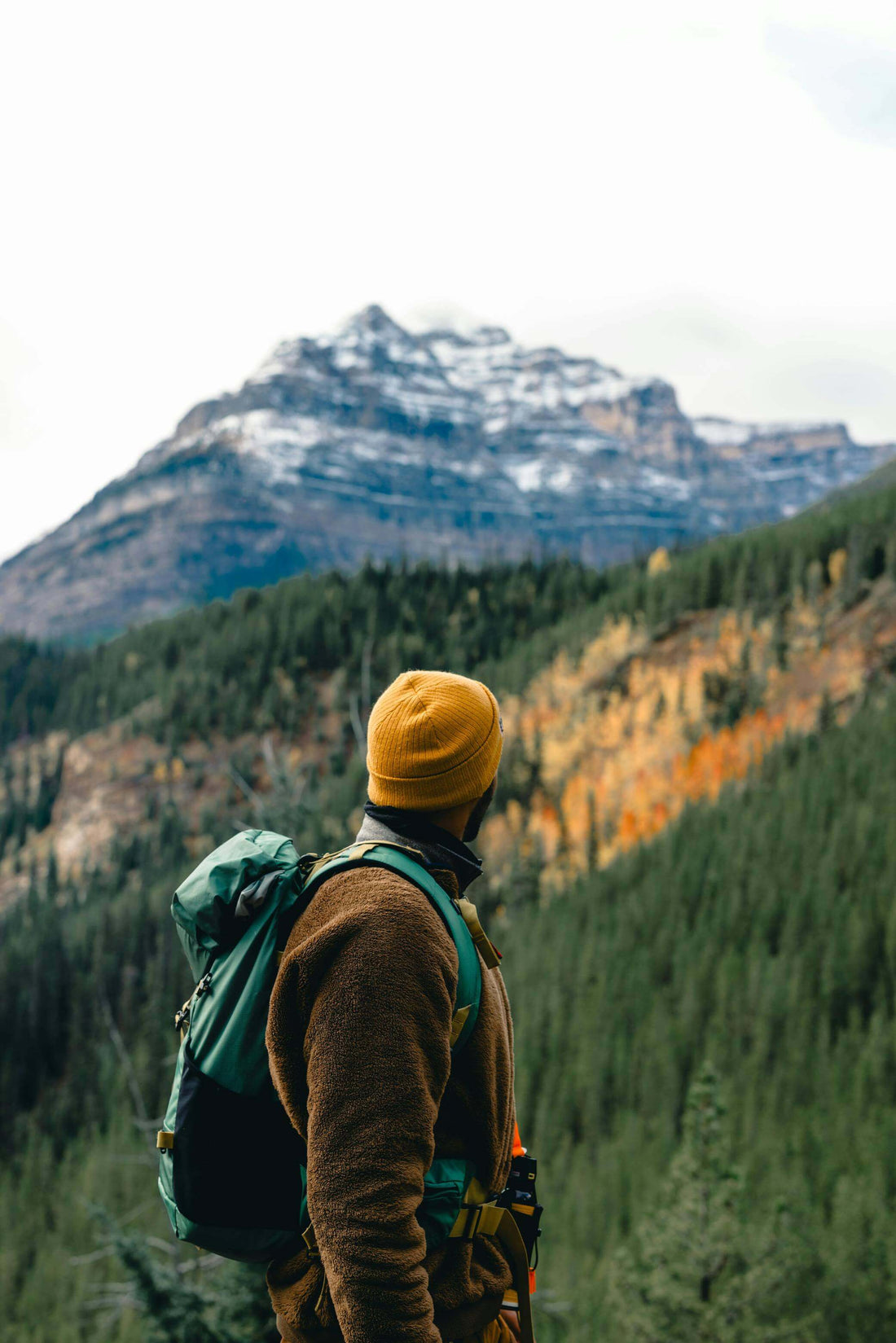 Male hiker overlooking Yosemite Valley at sunrise – soaking in the vast wilderness and granite peaks