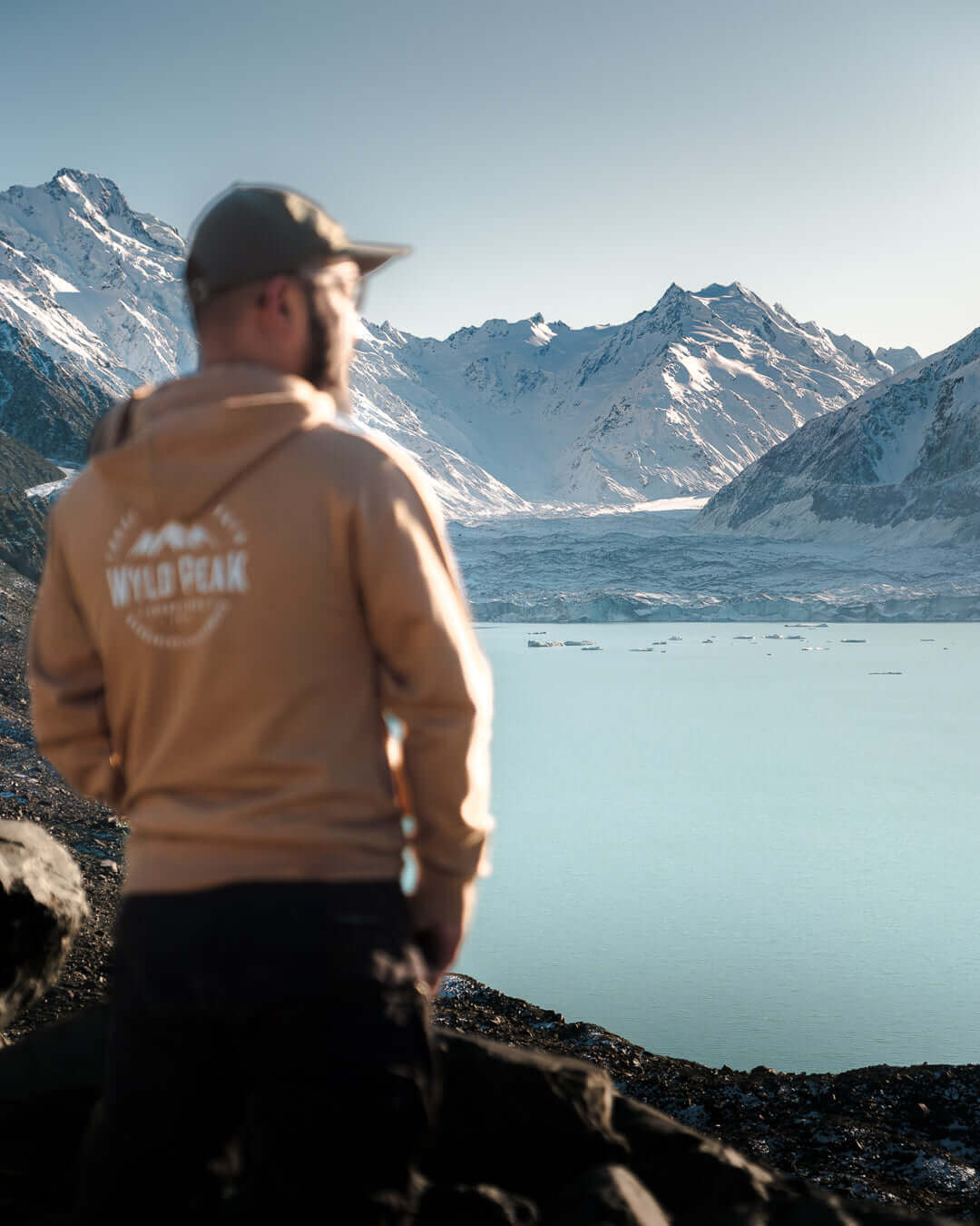 Photographer in Wyld Peak hoodie admiring Mount Cook summit at sunrise – solo hiking inspiration in alpine wilderness