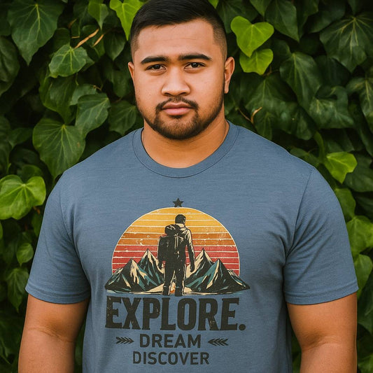 Man wearing a blue t-shirt with an 'Explore' graphic design against a green leafy background