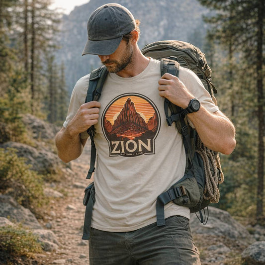 Man hiking in a forest wearing a 'Zion National Park' t-shirt.
