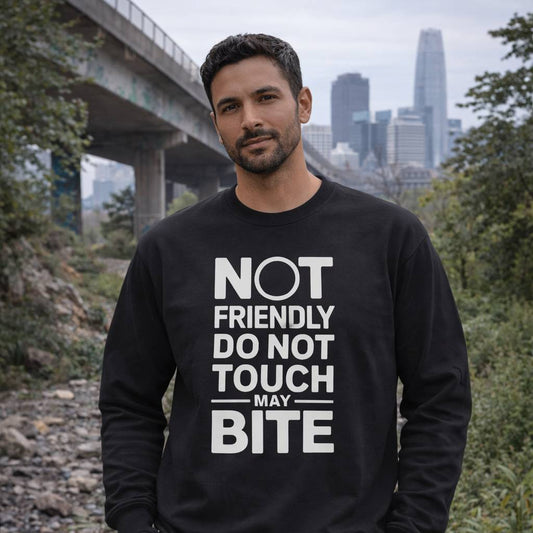 Man wearing a black sweatshirt with text in an outdoor setting with a city skyline.
