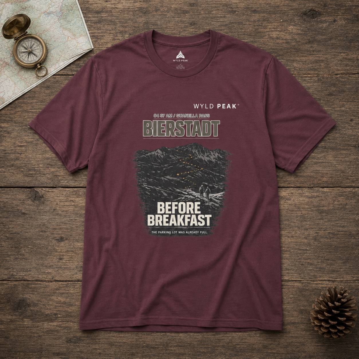 Maroon t-shirt with graphic design on a wooden surface