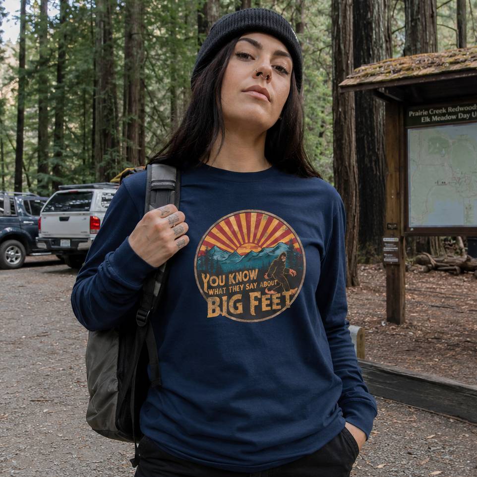 Person wearing a blue sweatshirt with a graphic design in a forest setting