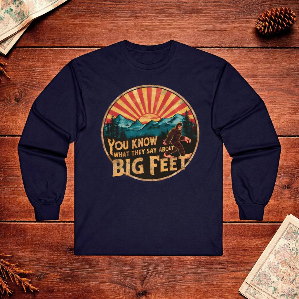 Navy blue long-sleeve shirt with mountain graphic and text on a wooden surface