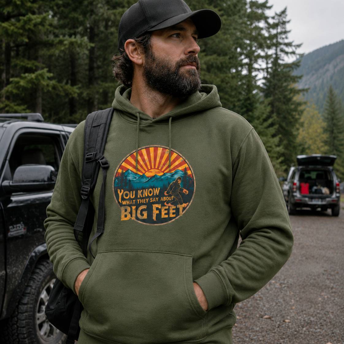 Man wearing a green hoodie with a graphic design in a forest setting
