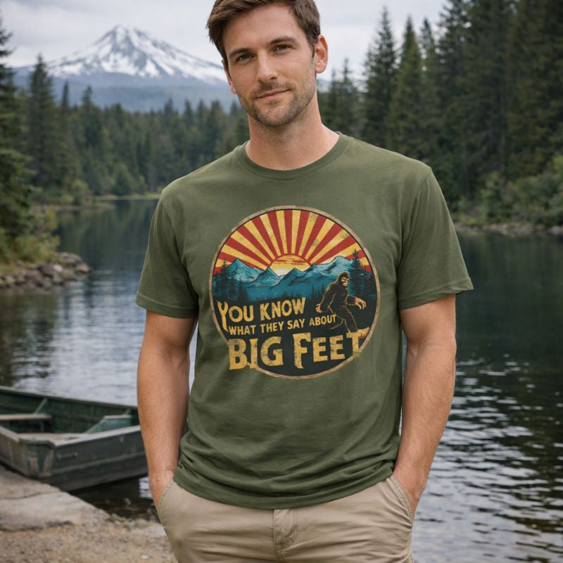 Man wearing a t-shirt with a graphic design by a lake and forest