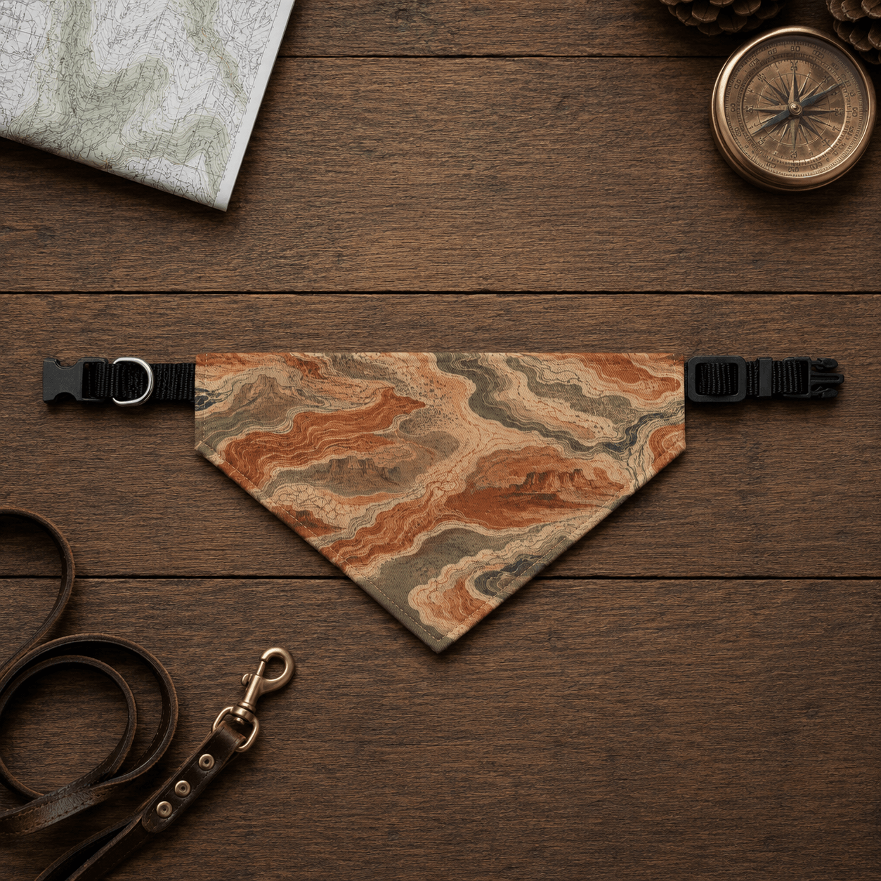 Dog bandana with map design on a wooden surface with leash and compass.