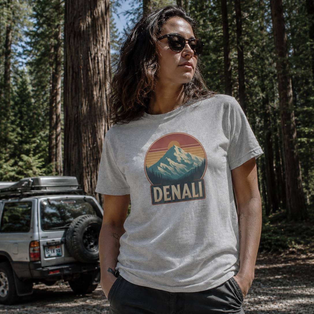Person wearing a t-shirt with Denali logo in a forest setting