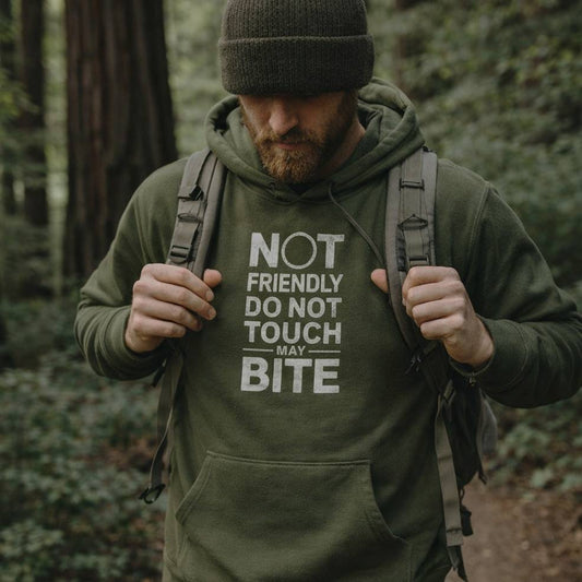 Man wearing a green hoodie with text in the forest