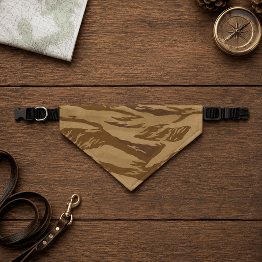 Camouflage dog bandana on a wooden surface with a map, compass, and leather leash.