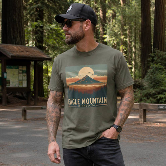 Man wearing a green t-shirt with 'Eagle Mountain Minnesota' design in a forest setting