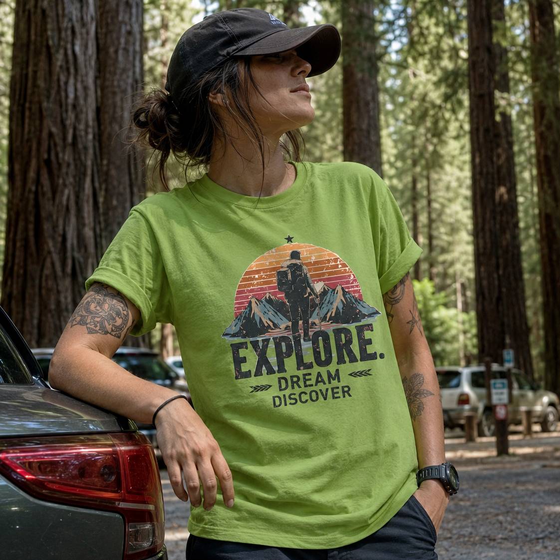 Person wearing a green t-shirt with 'Explore. Dream. Discover.' graphic in a forest setting.