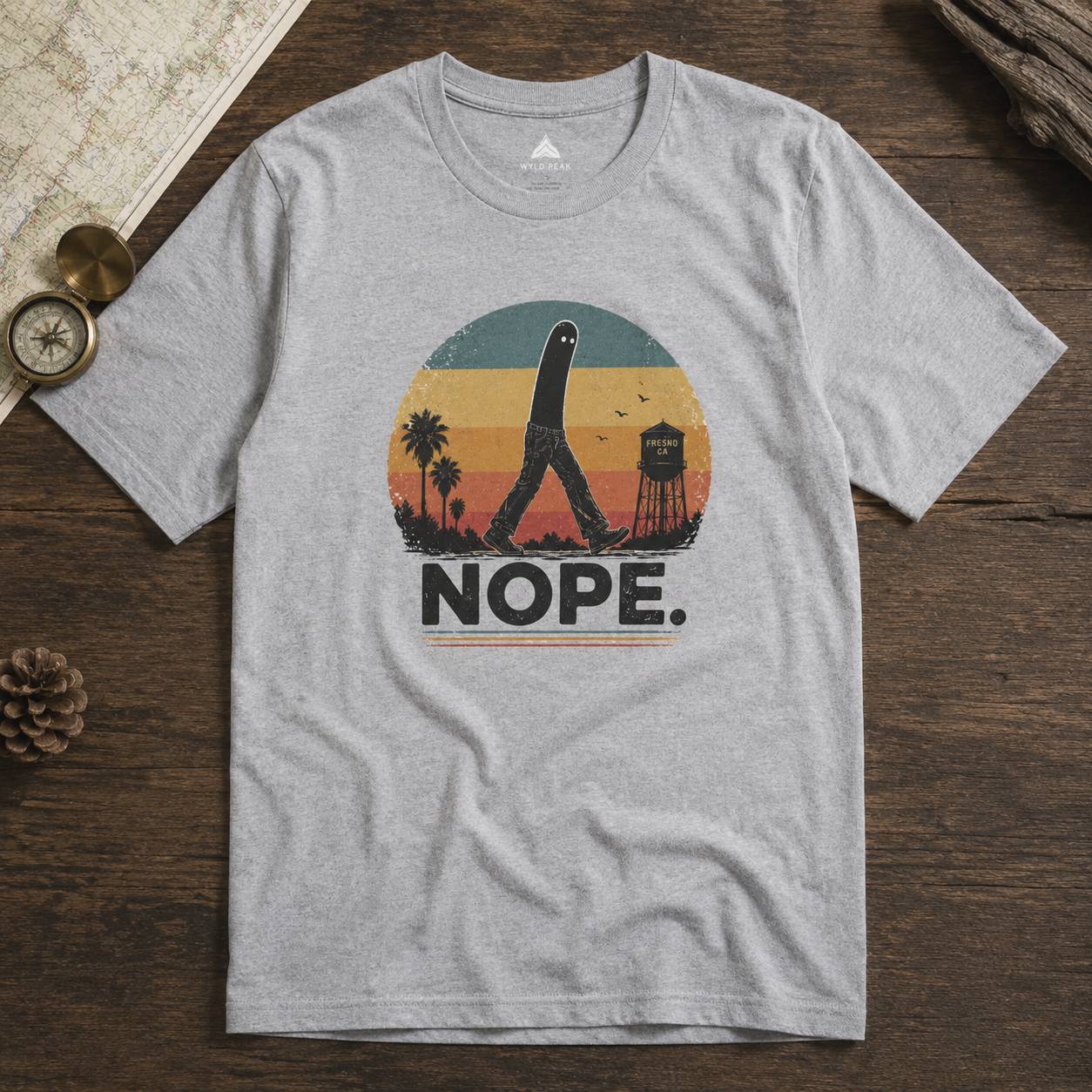 Gray t-shirt with a fresno nightcrawler graphic design and 'NOPE.' text on a wooden surface