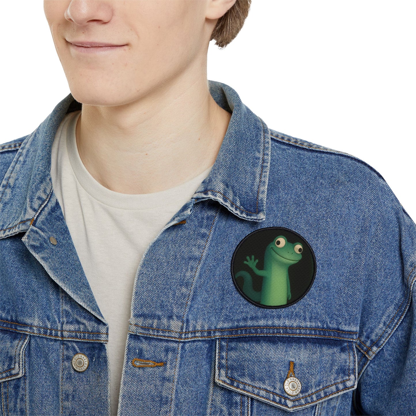 Grinning lizard meme iron-on patch on men’s denim jacket, funny reptile patch for apparel.