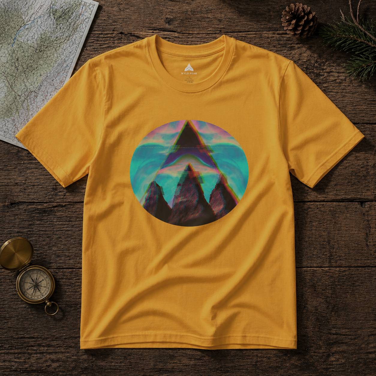 Yellow t-shirt with a mountain graphic on a wooden surface