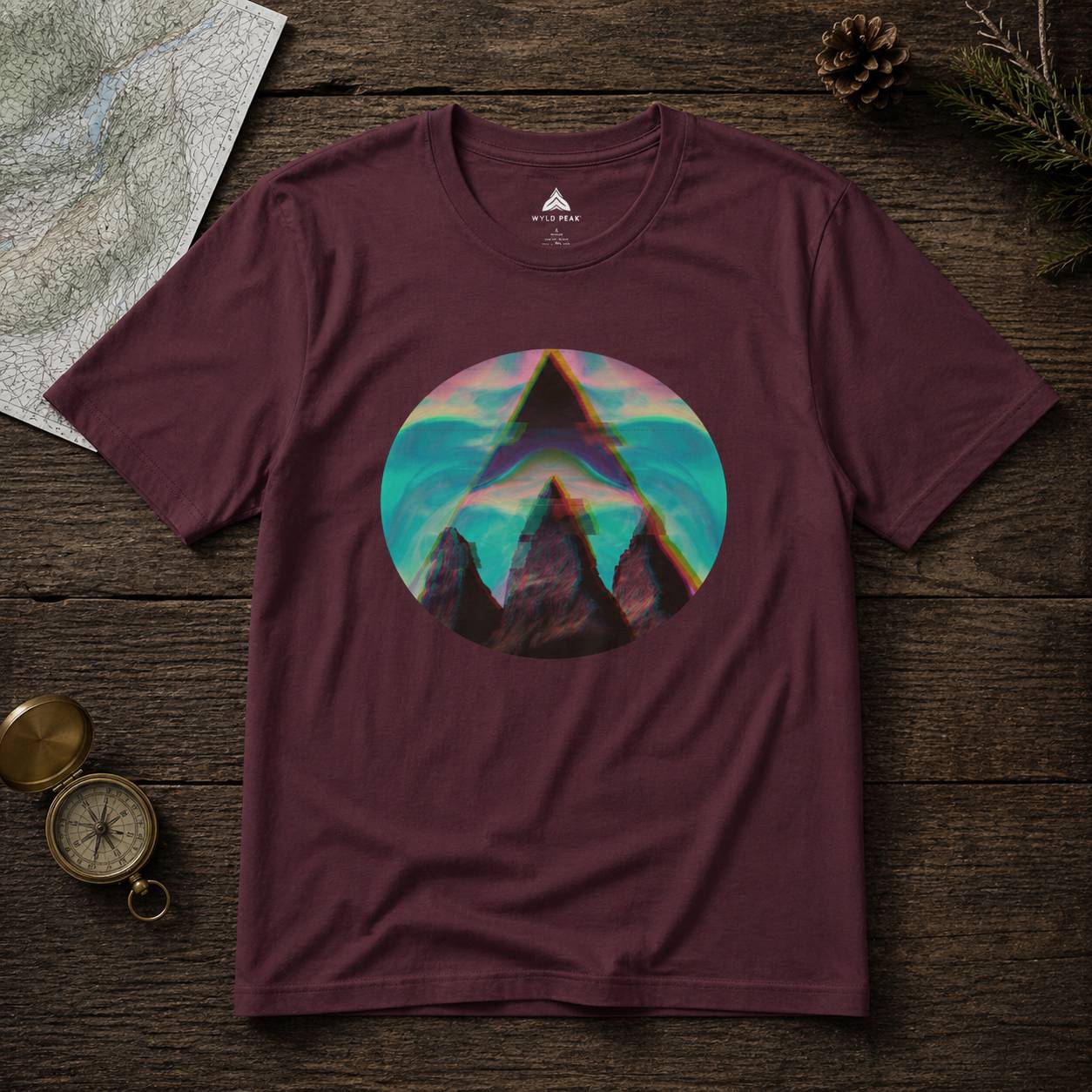 Maroon t-shirt with mountain graphic on a wooden surface