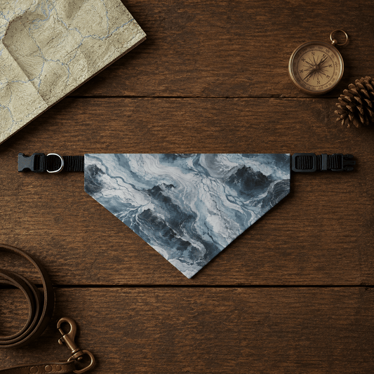 Glacier-patterned dog bandana on a wooden surface with a leash, compass, and pine cone.