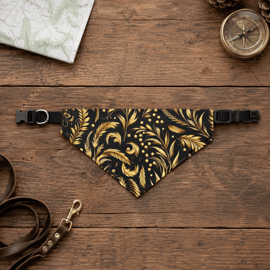 Black and gold patterned dog bandana on a wooden surface with a leash and compass.