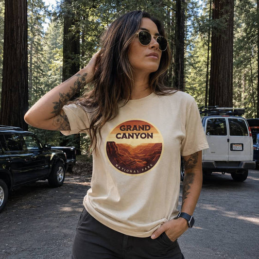 Woman wearing a t-shirt with Grand Canyon National Park design in a forest setting.