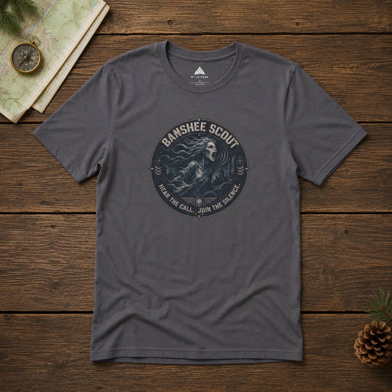 Gray t-shirt with 'Banshee Scout' graphic on a wooden surface