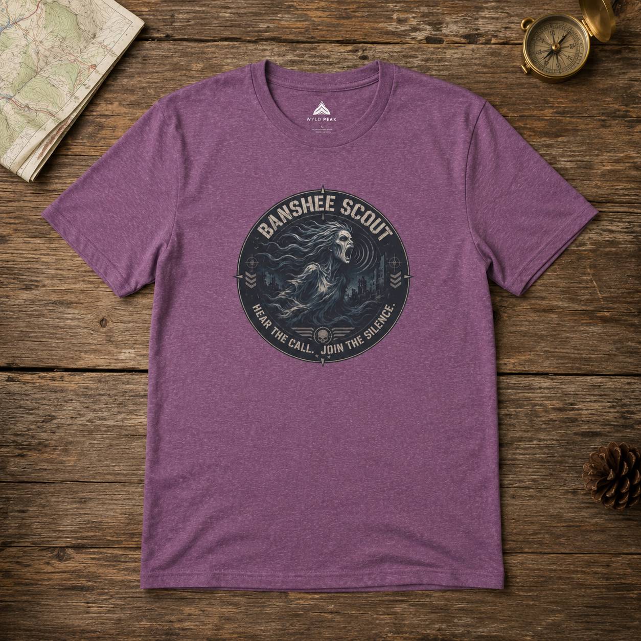 Purple t-shirt with 'Banshee Scout' graphic on a wooden surface