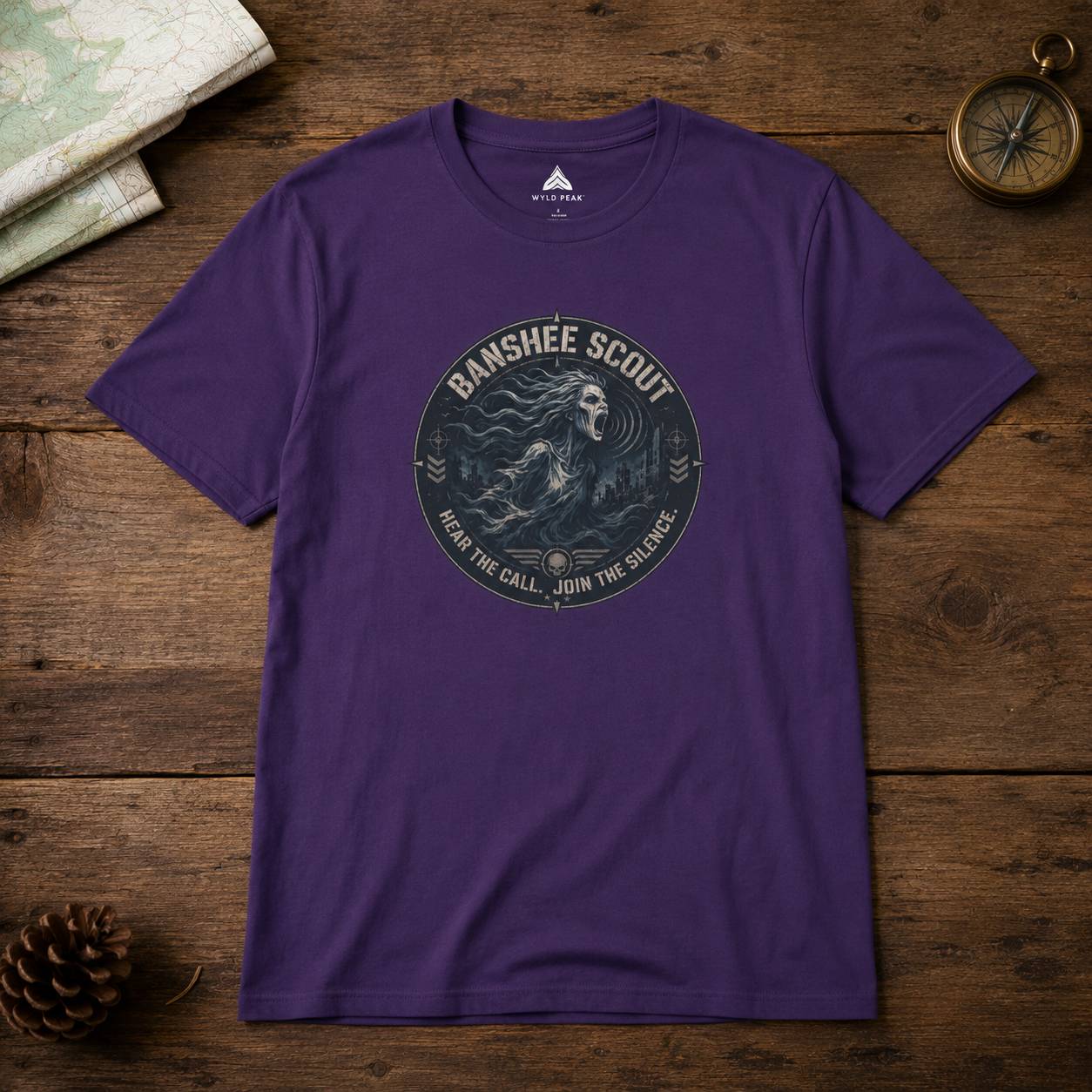 Purple t-shirt with 'Banshee Scout' graphic on a wooden surface