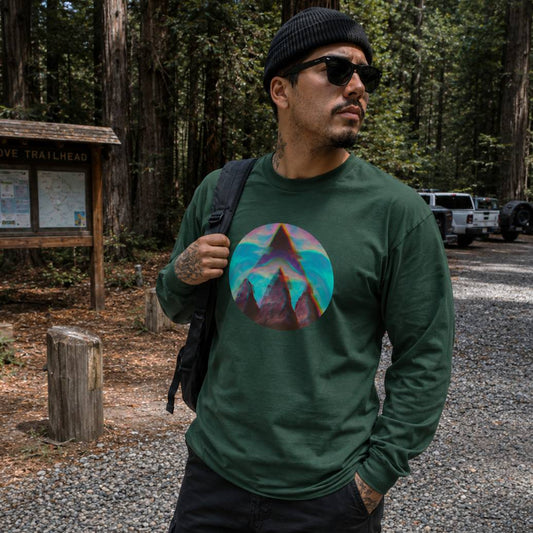 Man wearing a green long-sleeve shirt with a mountain graphic in a forest setting