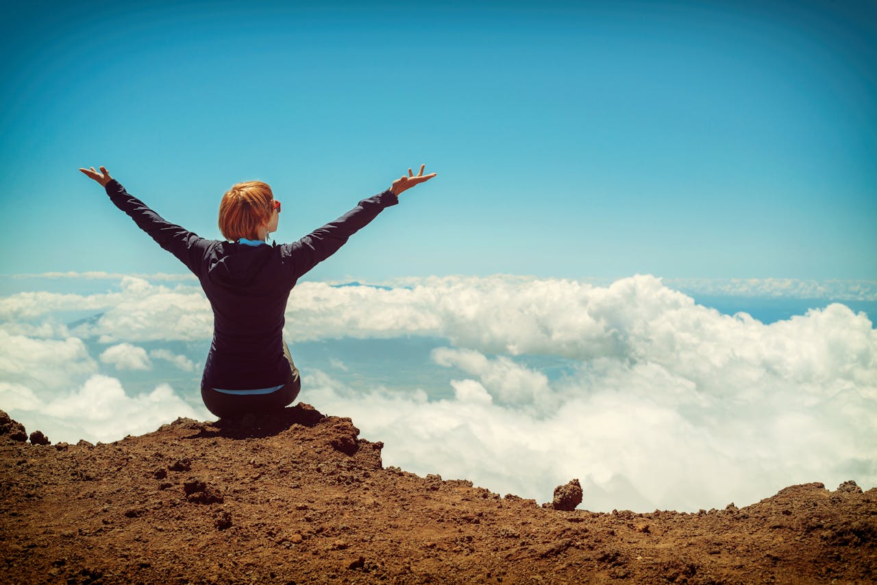 Female hiker enjoying a mountain summit view in Hawaii.