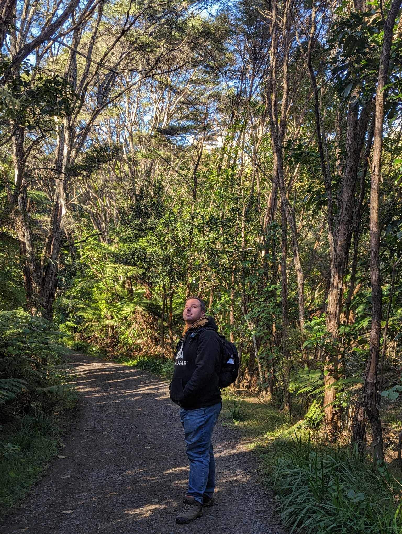 Hayden in Kauri Grove wearing a Wyld Peak logo hoodie.