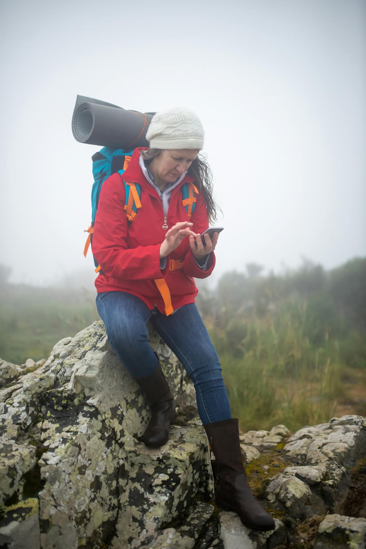 Hiker on a nature trail checking GPS location on her smartphone