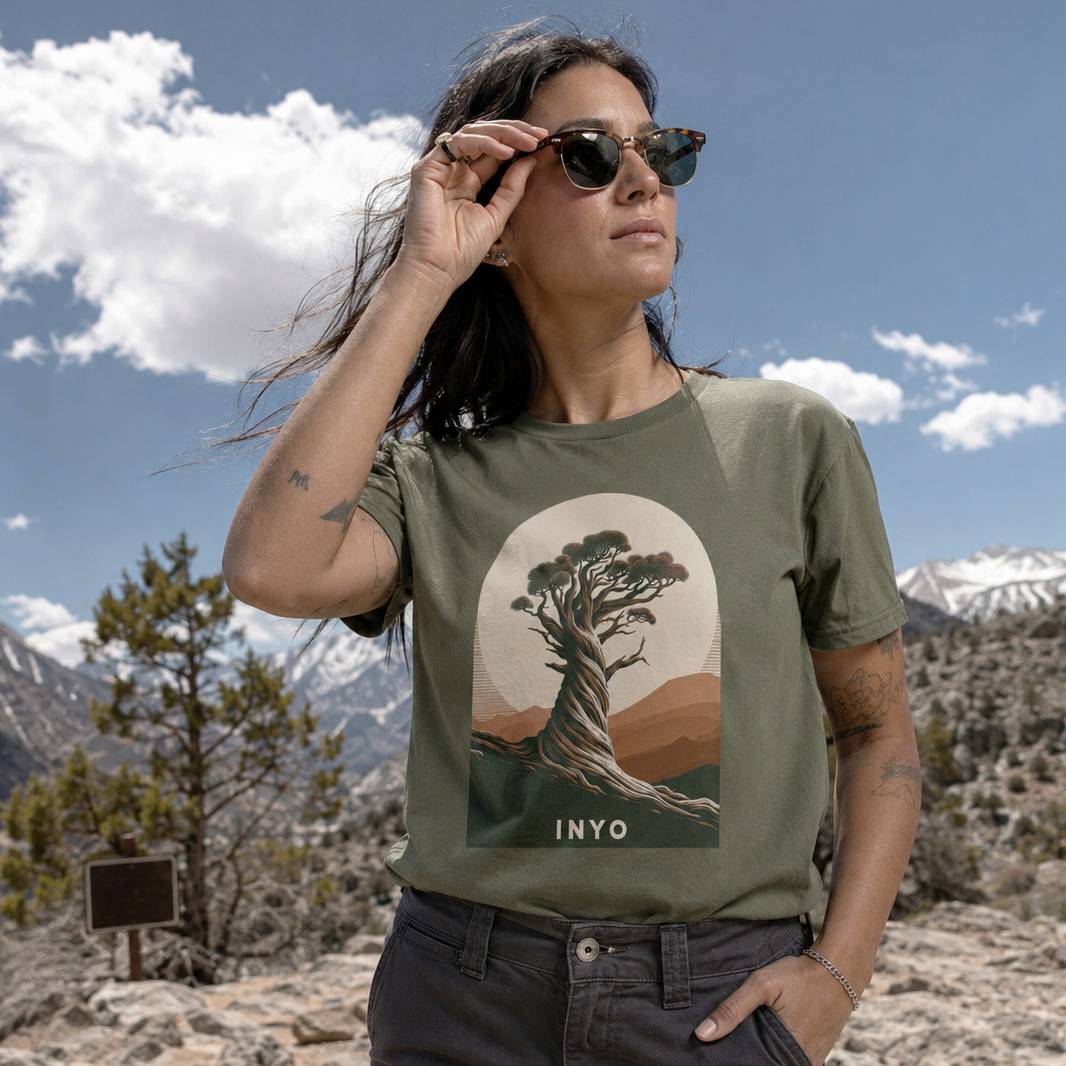 Woman wearing a t-shirt with a tree design in a mountainous landscape