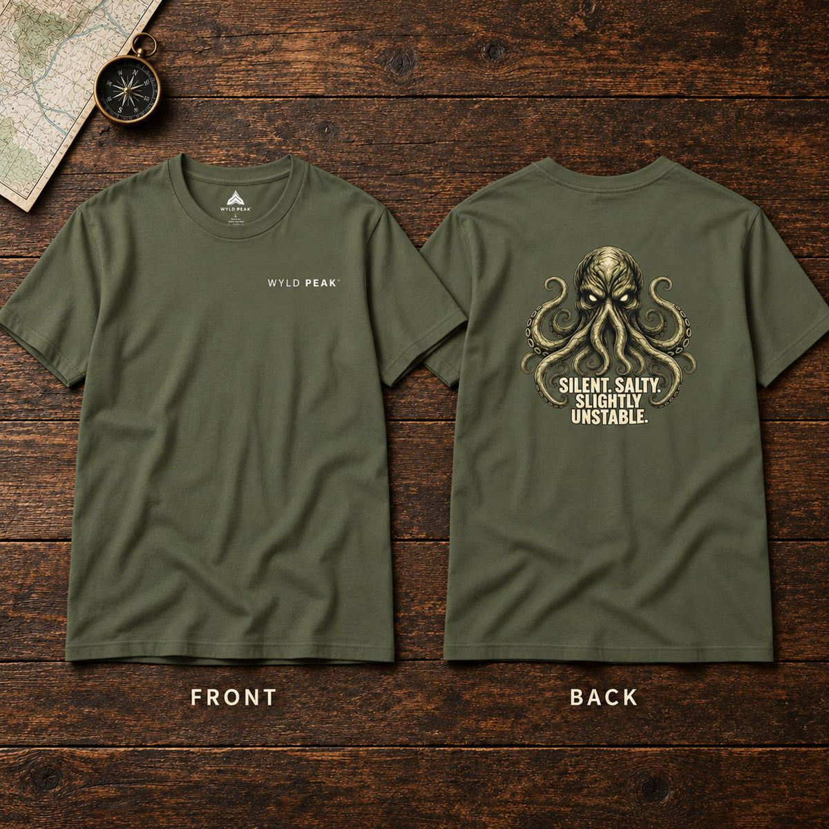 Front and back views of an olive green t-shirt displayed on a dark wood background. The front features a small white 'WYLD PEAK' logo on the left chest, while the back displays a large gold-toned octopus graphic with the text 'SILENT, SALTY, SLIGHTLY UNSTABLE.
