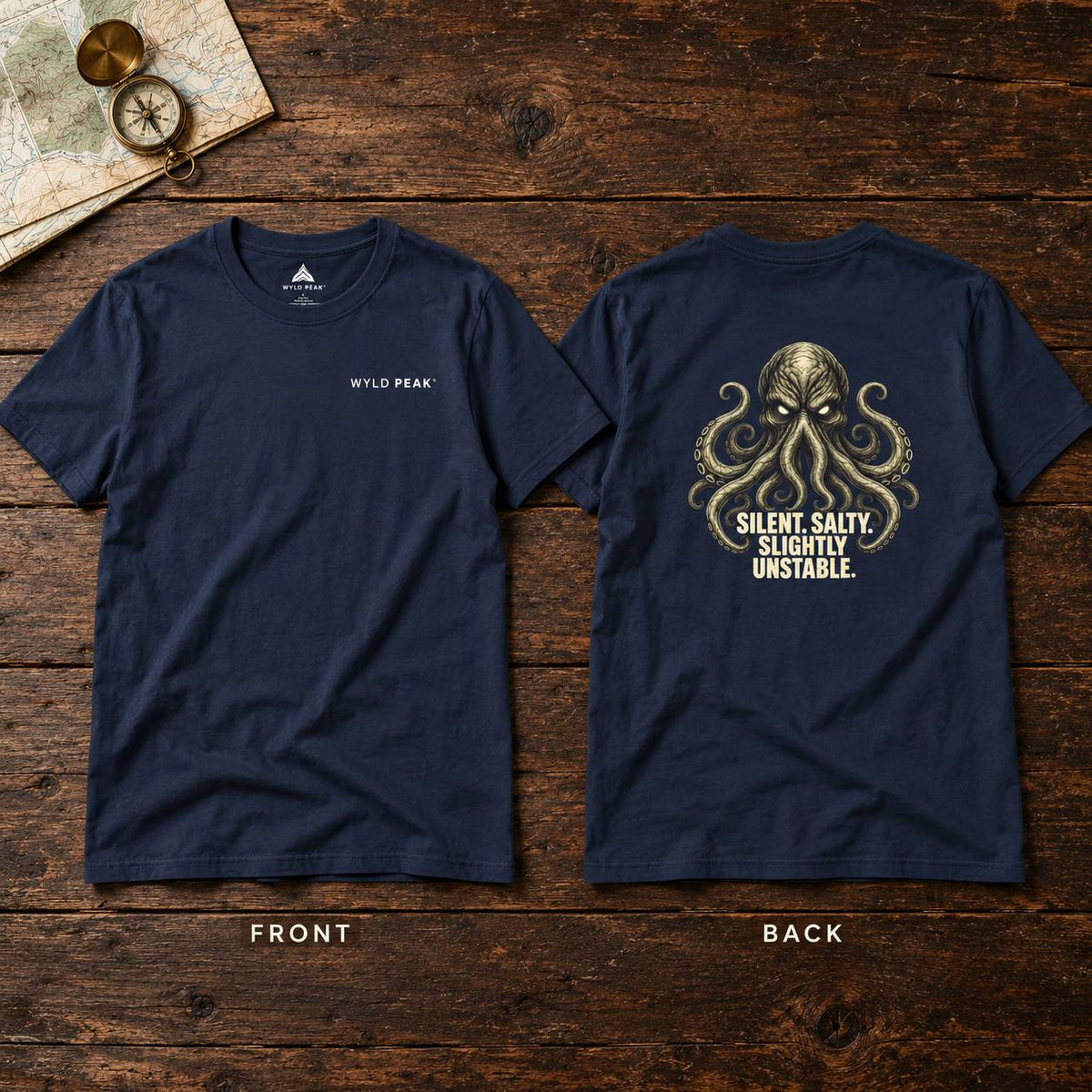 Front and back views of a navy blue t-shirt displayed on a rustic dark wood background. The front features a small white 'WYLD PEAK' logo on the left chest, while the back displays a large gold-toned octopus graphic with the text 'SILENT, SALTY, SLIGHTLY UNSTABLE.