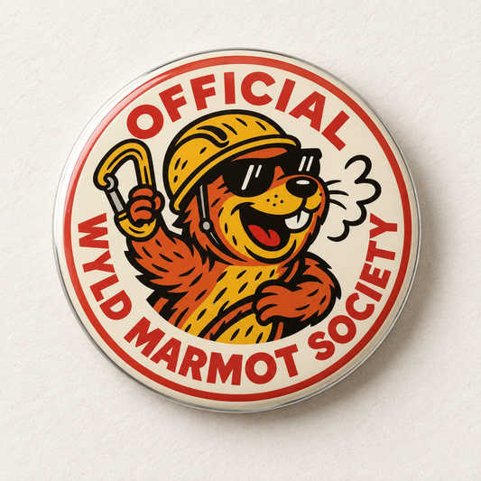 A round pinback button featuring a cartoon marmot wearing a yellow helmet and sunglasses, with the text 'OFFICIAL WYLD MARMOT SOCIETY' in red around the border, shown on a light textured background.