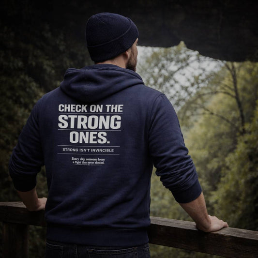 Person wearing a navy hoodie with suicide awareness mental health text, standing by a scenic view.