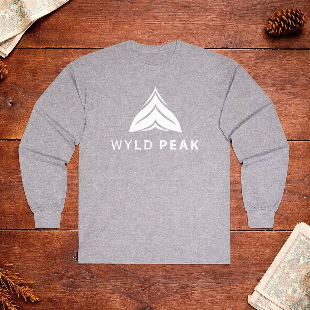 Gray long-sleeve shirt with 'WYLD PEAK' logo on a wooden surface