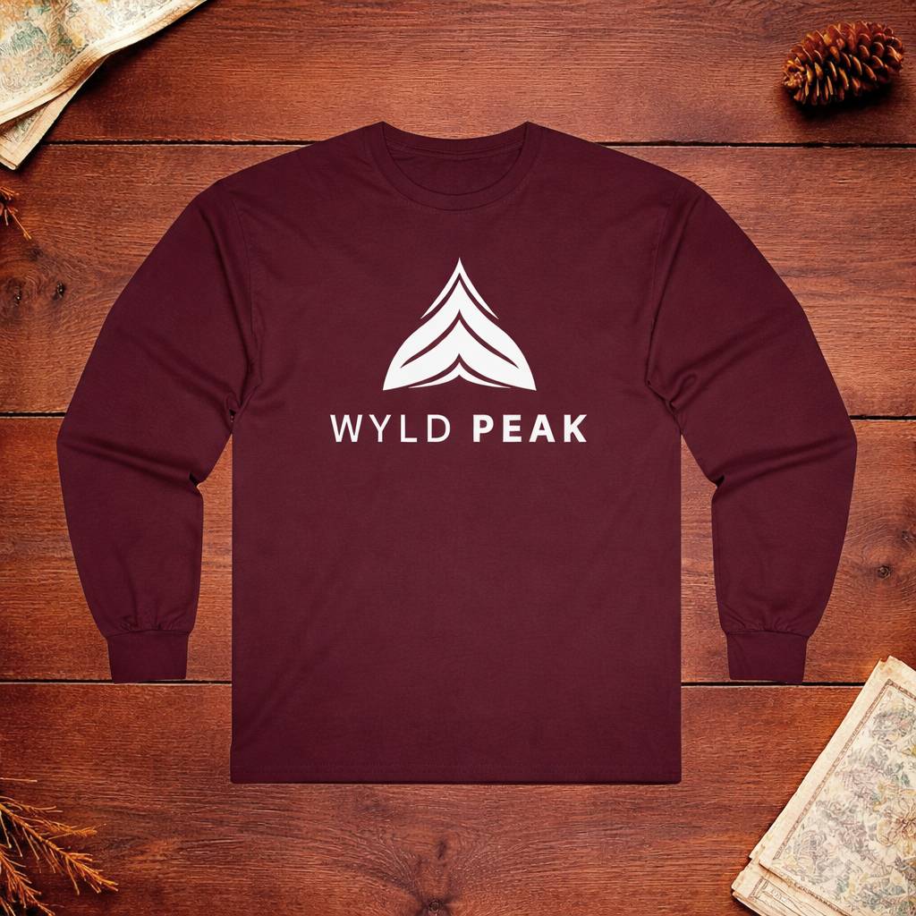 Maroon long-sleeve shirt with 'WYLD PEAK' logo on a wooden surface