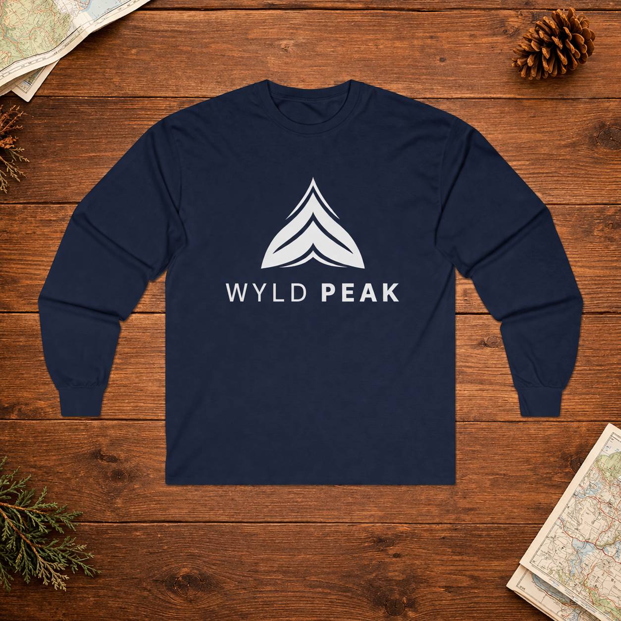 Navy blue long-sleeve shirt with 'Wyld Peak' logo on a wooden surface.