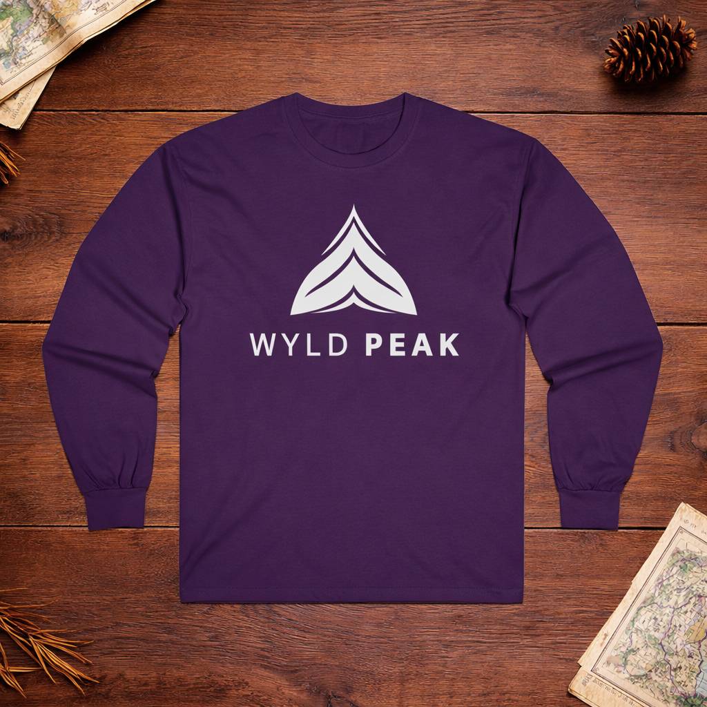 Purple long-sleeve shirt with 'WYLD PEAK' logo on a wooden surface