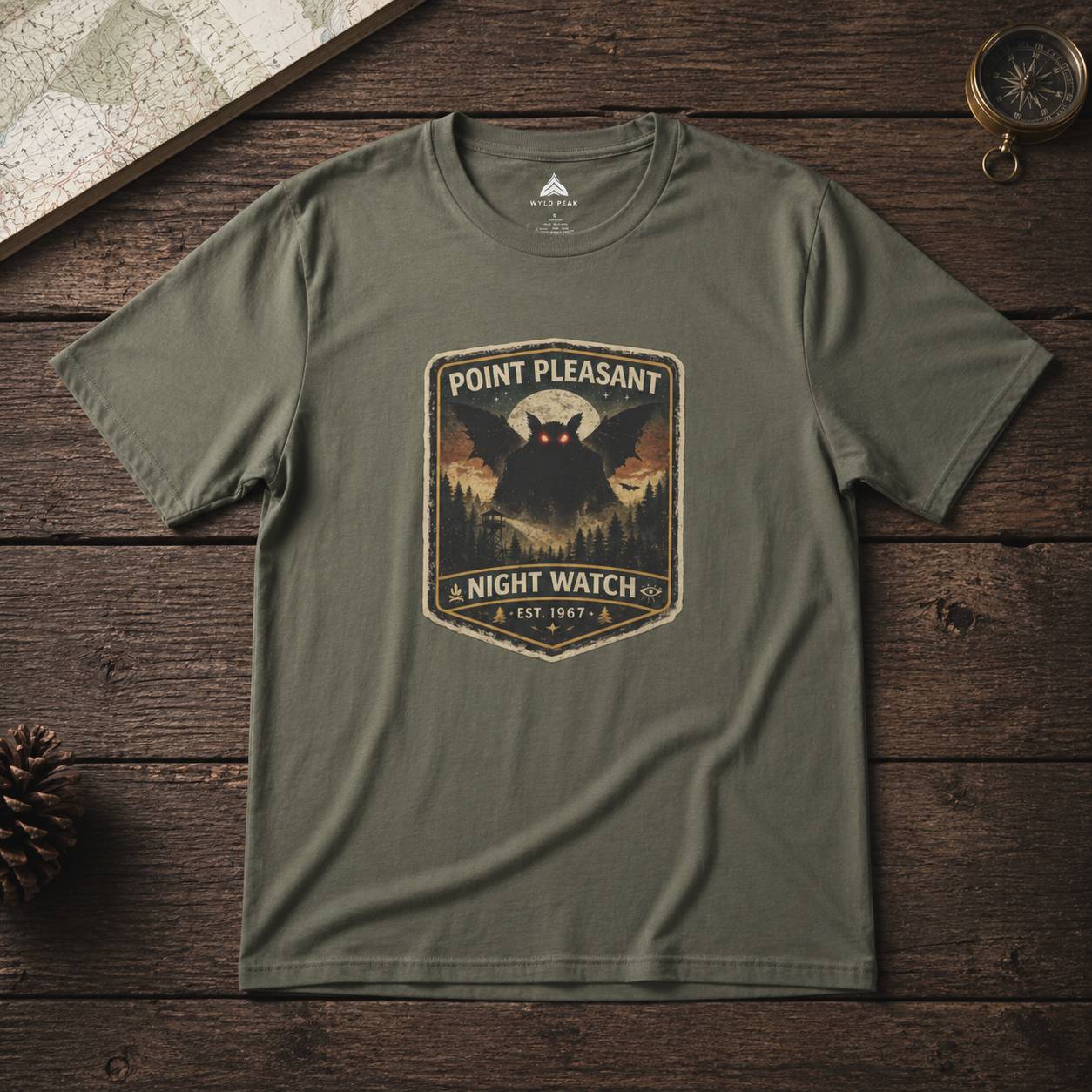 Green t-shirt with 'Point Pleasant Night Watch' graphic on a wooden surface