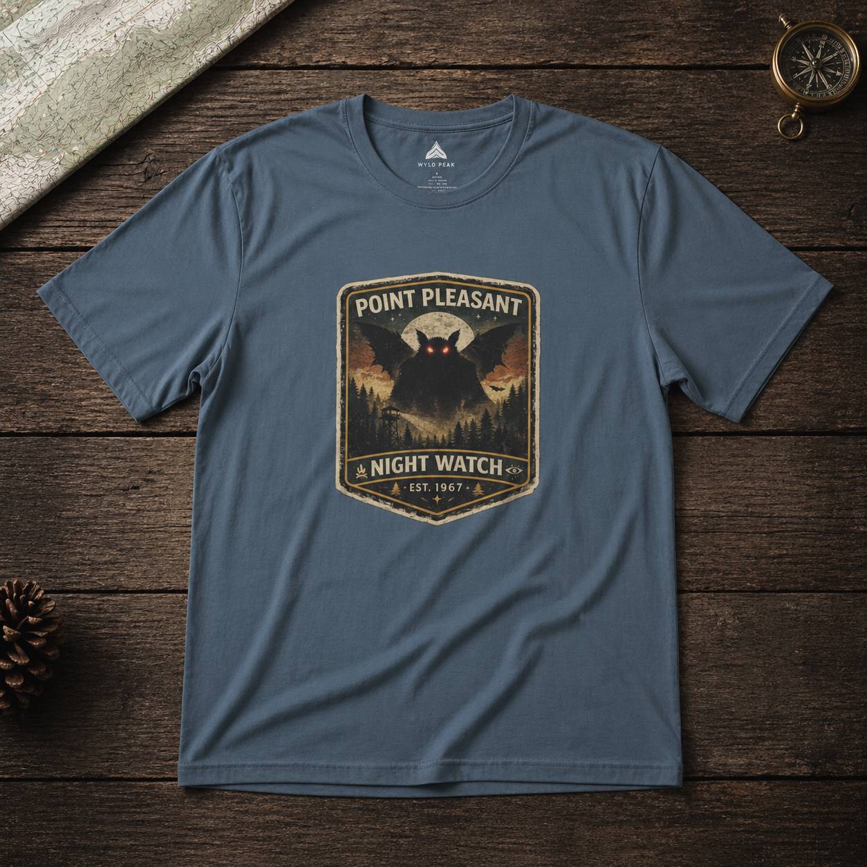 Blue t-shirt with 'Point Pleasant Night Watch' graphic on a wooden surface