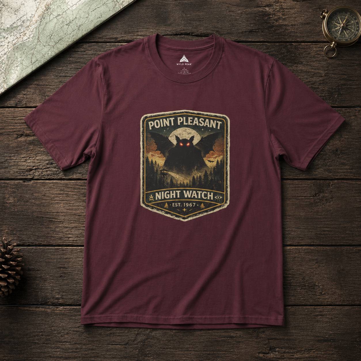 Maroon t-shirt with 'Point Pleasant Night Watch' graphic on a wooden surface