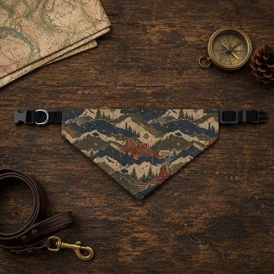 Dog bandana with mountain design on a wooden surface with leash, map, and compass.