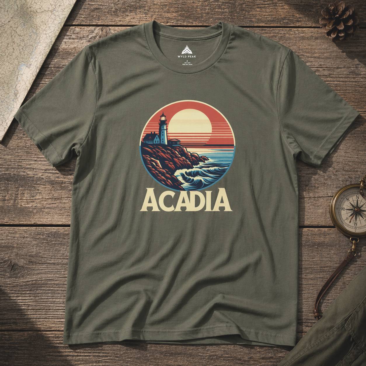 Green t-shirt with Acadia national park graphic on a wooden surface