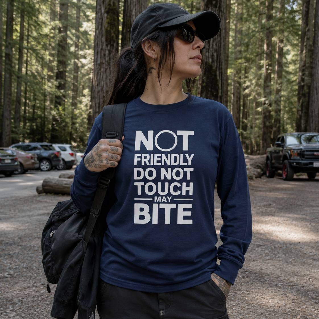 Person wearing a navy blue sweatshirt with text in a forest setting