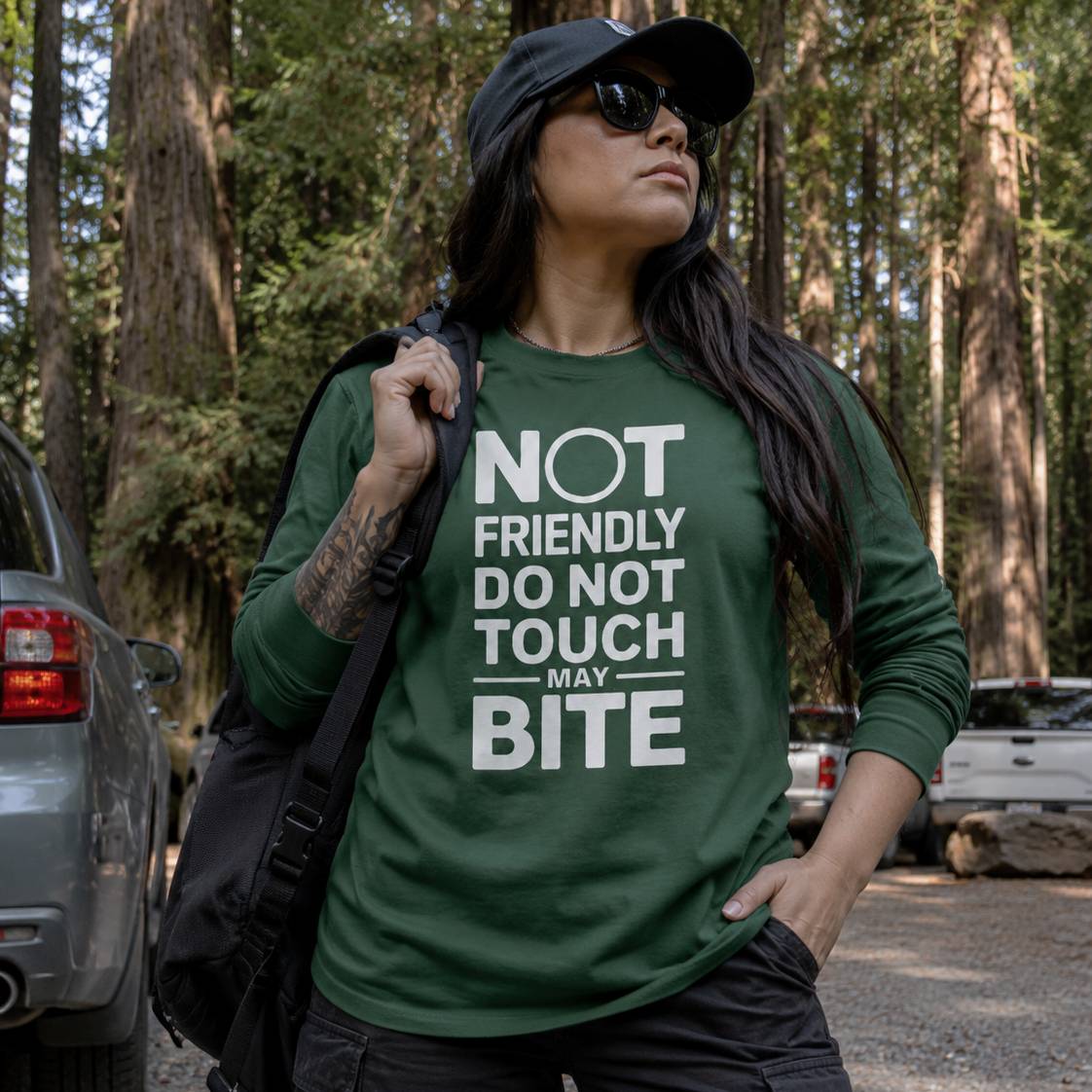 Person wearing a green shirt with text in a forest setting